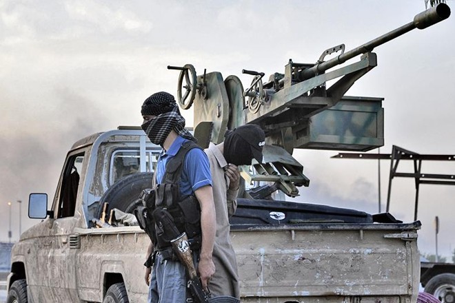 Phiến quân nhà nước Hồi giáo tự xưng ISIS bên cạnh chiếc xe bán tải chất đầy vũ khí 