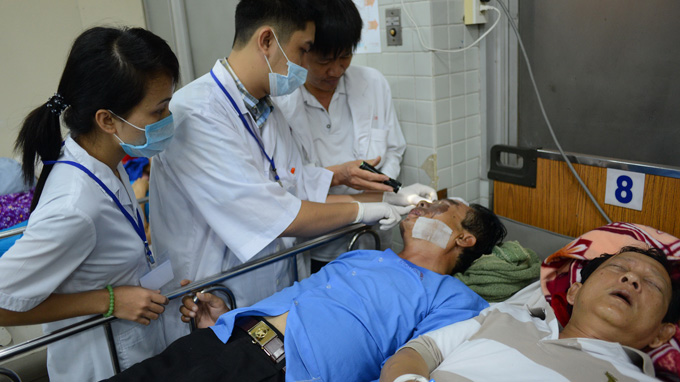 Bác sĩ Bệnh viện Chợ Rẫy, TP.HCM khám cho nạn nhân vụ tạt axit - Ảnh: Quang Định
