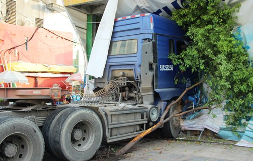 Đầu xe container húc đổ cây xanh và bức tường công trình tại hiện trường vụ tai nạn giao thông