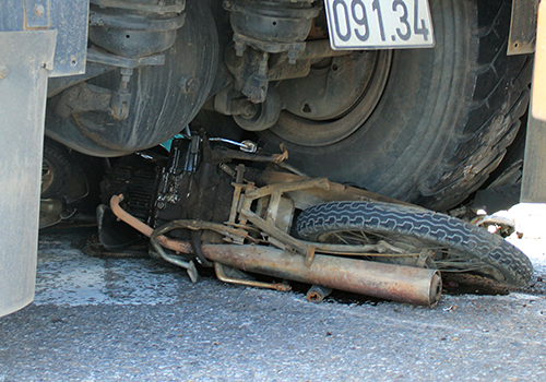 Xe máy cùng thi thể người phụ nữ kẹt cứng dưới bánh xe đầu kéo tại hiện trường vụ tai nạn giao thông chết người