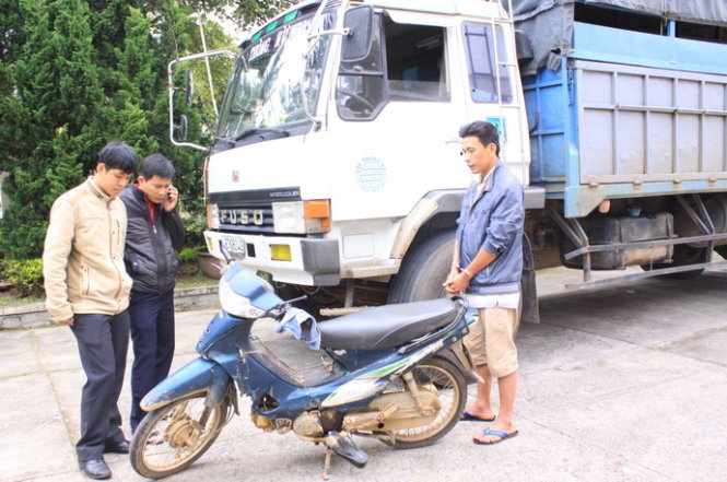 Lái xe Trương Hồng Duy (bị còng tay) bên chiếc xe tải gây tai nạn giao thông chết người