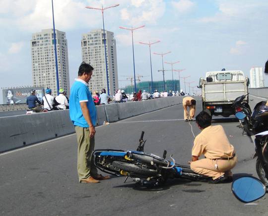Lực lượng chức năng xử lý hiện trường vụ tai nạn giao thông giữa xe ba gác và xe máy trên cầu Sài Gòn