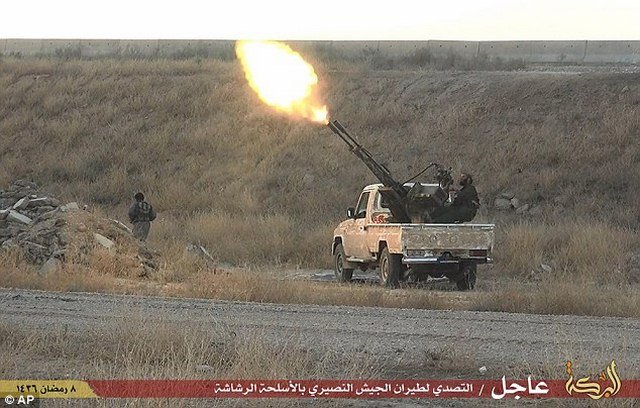 Một phiến quân khủng bố IS bắn đạn từ một khẩu súng phòng không trên thùng sau xe tải ở thành phố Hassakeh (Syria)