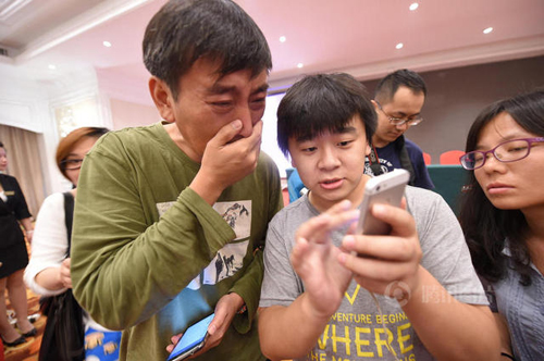 Con trai bà Chu nghẹn ngào khi thấy ảnh mẹ - một nạn nhân trong vụ tai nạn chìm tàu Trung Quốc - được cứu sống trên báo chí