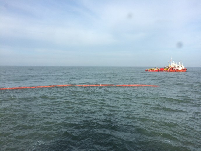 Lực lượng chức năng đã cho thả phao vây quanh tàu Hoàng Phúc khống chế lượng dầu loang. 