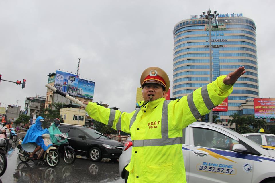 Một cán bộ CSGT Hà Nội đang phân làn giao thông trong mưa bão