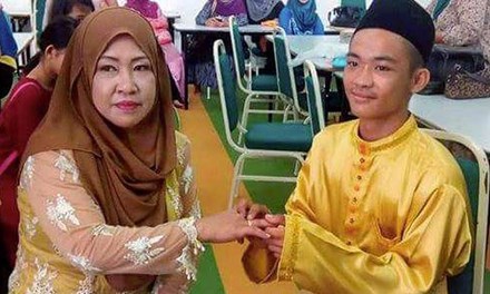 Chú rể Sufie, 18 tuổi, trao nhẫn cho cô dâu Sopiah, 42 tuổi, trong lễ cưới. Ảnh: HARIAN METRO/FACEBOOK
