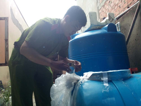 Công an niêm phong bồn chứa dùng để sản xuất nước mắm. Ảnh TN