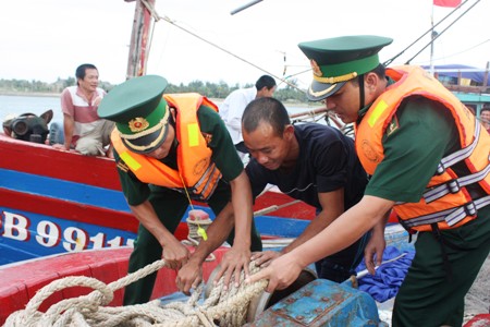 Lực lượng BĐBP Quảng Bình đang phối hợp với ngư dân đưa các phương tiện về nơi trú bão an toàn. 