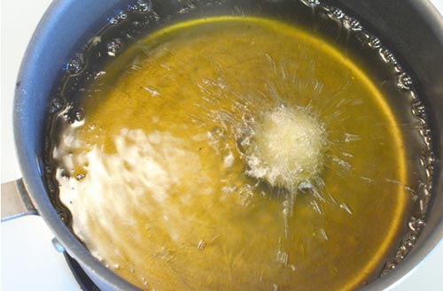 Đổ dầu vào chảo sâu lòng để bánh được chiên ngập dầu, đun đến khi dầu nóng già (nhúng đũa vào dầu thấy dầu sủi bọt ở đầu đũa).