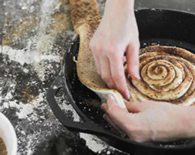 Đặt phần bột vừa cuộn vào khay nướng tròn hoặc chảo dày, sau đó cuộn lần lượt các dải bột còn lại ra ngoài sao cho đầy khay. Sau khi cuộn xong, đậy bánh lại rồi ủ tiếp trong 45 phút nữa cho bánh nở ra.