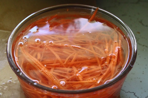 Bào sợi cà rốt trộn vào cà rốt nửa thìa nhỏ đường, ba thìa canh nước lạnh, nửa thìa nhỏ muối, nửa thìa nhỏ giấm,nêm hơi chua ngọt.