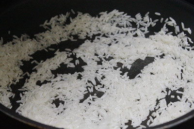 Đun nóng chảo, đổ gạo vào rang đến khi hạt gạo se lại. Tiếp theo đổ gạo vào nồi nhỏ, đổ nước lạnh xâm xấp với mặt gạo, đun sôi đến khi hạt gạo nở bung ra thì đổ ra rá sạch, đổ bỏ phần nước lạnh đun cùng với gạo.