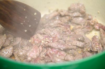 Cho dầu ăn vào nồi, bật bếp đun nóng thì đổ thịt bò vào xào khoảng 2 phút lửa lớn.