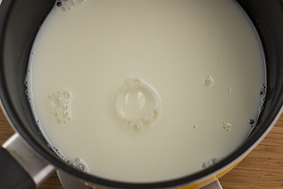 Các bạn cho sữa vào một nồi, đun nhỏ lửa. Lưu ý trong lúc đun khuấy đều liên tục, không để sữa bị cháy, sẽ ảnh hưởng đến mùi vị của kem. Đến khi sữa bắt đầu sủi bọt và có bọt li ti ở thành nồi thì tắt lửa, bắc ra khỏi bếp.