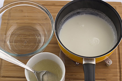 Đổ sữa nóng vào 1 bát sạch, cho tiếp hỗn hợp gelatin và nước vào bát sữa. Dùng máy đánh trứng đánh đến khi được hỗn hợp tan đều, đồng nhất.