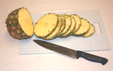 Dùng dao cắt trái thơm (dứa) thành nhiều phần theo chiều ngang, có độ dày khoảng 1,25 đến 1,5 cm.