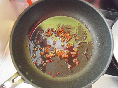 Làm nóng dầu trong chảo, cho ớt khô, tiêu sọ vào phi thơm.