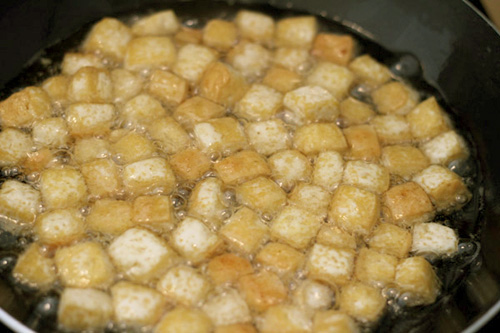 Làm nóng dầu ăn trong chảo, rồi cho đậu phụ vào rán cho vàng hai mặt.
