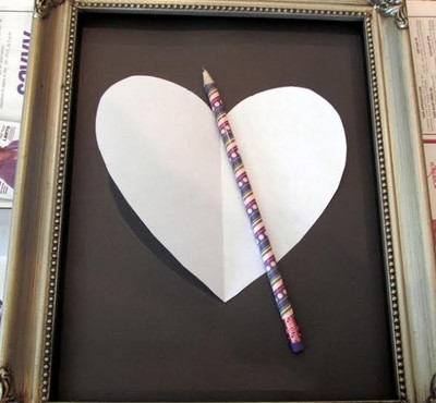 Vẽ hình trái tim trên tấm giấy trắng mỏng, sao cho kích thước trái tim nhỏ hơn nền khung tranh. Đặt trái tim trên nền khung tranh và căn ke theo mẫu bằng bút chì.