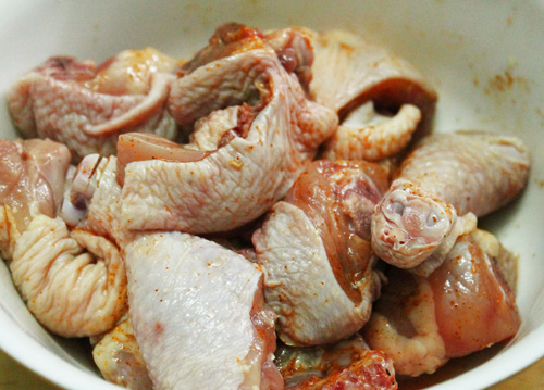 Thịt gà rửa sạch rồi chặt miếng nhỏ vừa ăn. Khứa vài đường trên bề mặt các miếng thịt. Đem ướp thịt cùng 15g bột nêm, 10ml mật ong và 5g ớt bột.