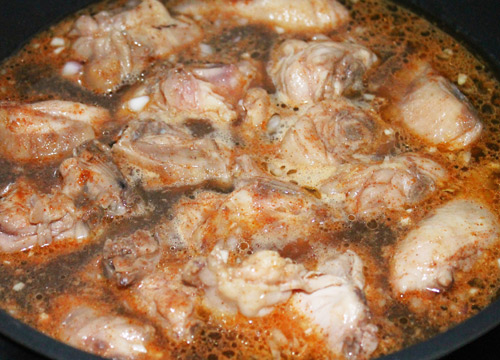 Khi thịt gà chuyển sang màu vàng, nhẹ nhàng đổ nước sốt vào chảo, tiếp tục nấu đến khi nước sốt sánh lại.