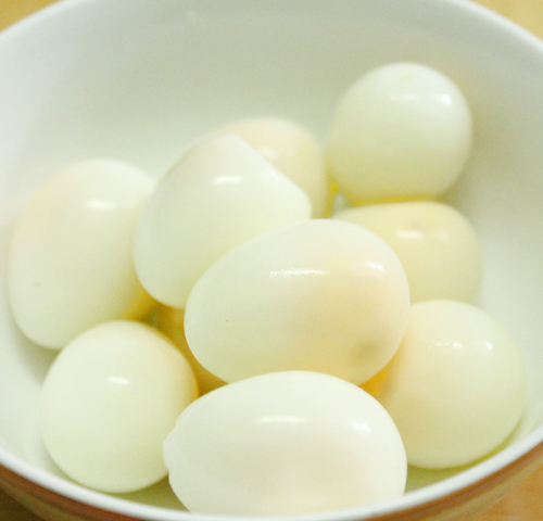 Đem trứng cút đi luộc và bóc sạch vỏ.