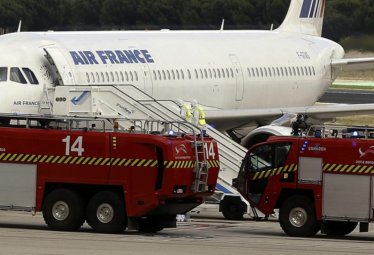 Nhân viên y tế mặc quần áo bảo hộ đứng bên cạnh máy bay A321 của Air France Airbus. Chiếc máy bay đã hạ cánh xuống sân bay quốc tế Barajas ở thủ đô Madrid của Tây Ban Nha vào ngày 16 Tháng Mười năm 2014