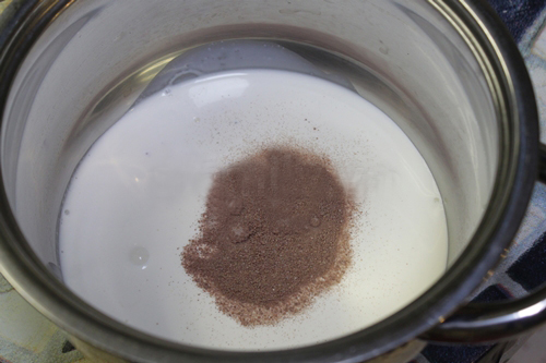 Trộn kem sữa tươi và bột cacao trong một nồi nhỏ