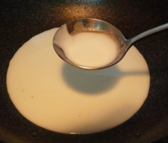 Khi thấy sữa đã ấm, cho nửa muỗng canh to nước cốt dừa vào. Nước cốt dừa giúp ca cao uống ngậy và thơm hơn.