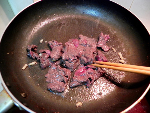 Cho thịt bò vào xào sơ, bạn nên để bếp ở mức lửa to.