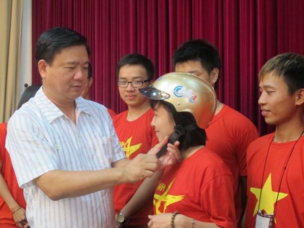 Bộ trưởng Đinh La Thăng trao mũ bảo hiểm cho các thành viên của nhóm phượt Phong Vân.