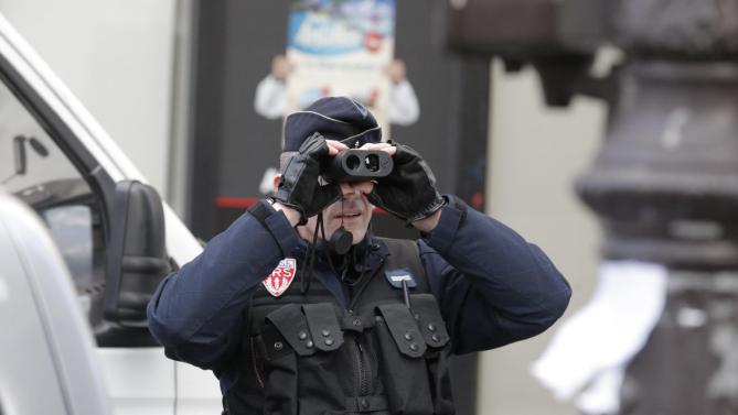 Cảnh sát Pháp dùng ống nhòm để quan sát khi tham gia bảo vệ an ninh cho cuộc tuần hành ở Paris ngày 12/1