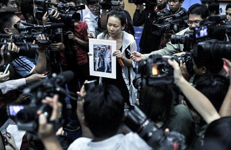 Một thân nhân hành khách trên chuyến bay MH370 cầm tấm ảnh của Thủ tướng Malaysia Najib Razak với dòng chữ: 'Xin hãy trả lại chồng tôi'
