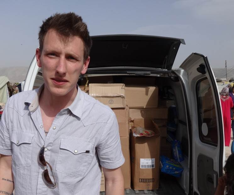 Peter Kassig đứng cạnh xe tải chất đầy hàng cứu trợ cho người dân tị nạn Syria trong cuộc chiến chống khủng bố IS