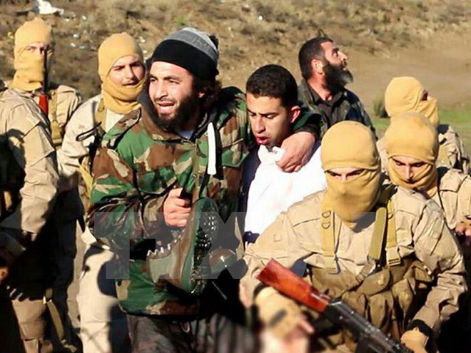 Maaz al-Kassasbeh (giữa) bị khủng bố IS bắt ngày 24/12 tại Raqa, miền bắc Syria 