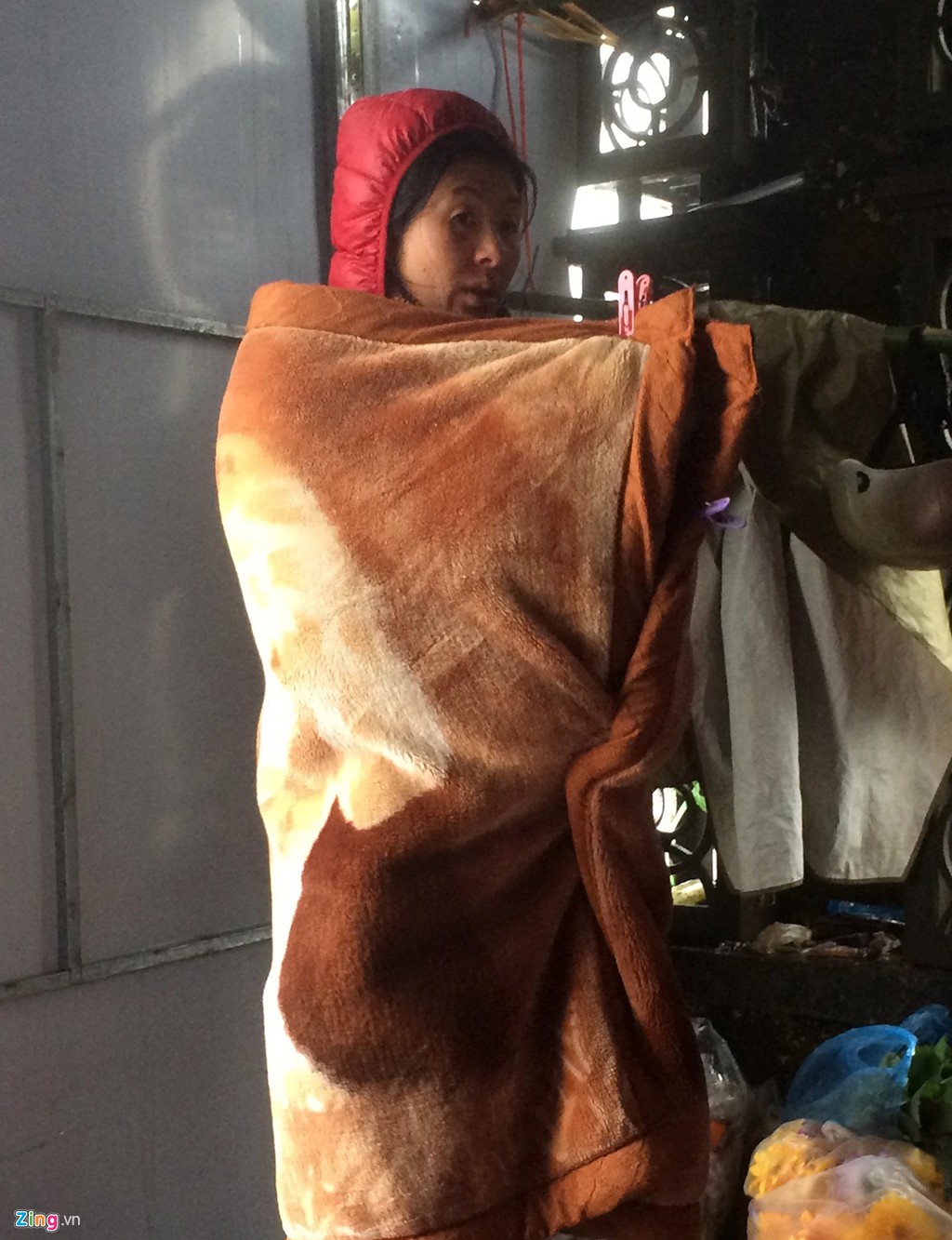 Hình ảnh người dân co ro tìm cách chống giá lạnh xuất hiện ở khắp nơi trong khu vực thị trấn Sapa và các bản làng quanh vùng. Trong ảnh, một phụ nữ quàng chăn len khi rảnh tay. Chị cho biết, ngồi xuống rất lạnh, phải đứng mới đỡ rét run.
