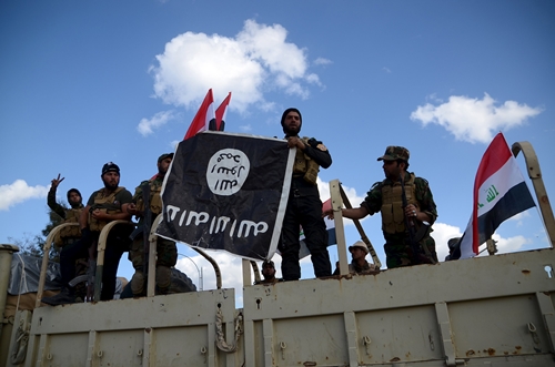Các tay súng bán quân sự dòng Shiite cầm lá cờ đen của Nhà nước Hồi giáo mà họ vừa gỡ xuống ở Tikrit hôm 31/3