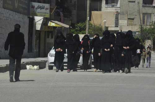 Các nữ sinh ở trường dành cho nữ đi bộ trên đường ở thành phố Raqqa hồi tháng 3/2014