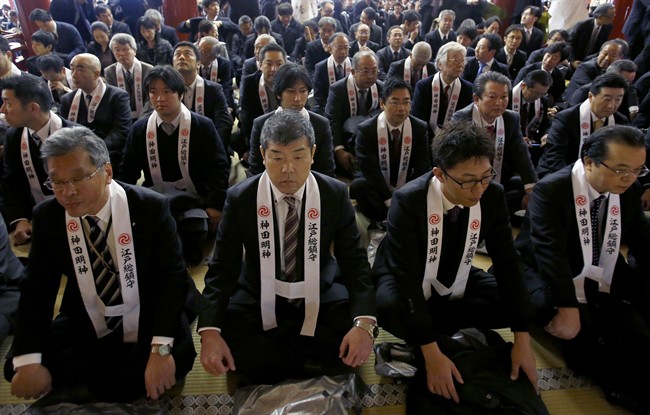 Nhân viên công ty Nhật Bản ngồi cầu nguyện cho một năm kinh doanh tốt  tại đền Kanda Myojin