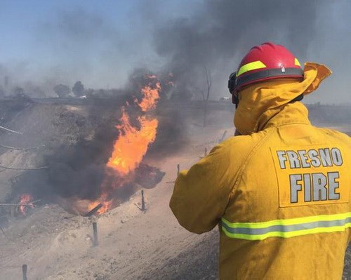 Một lính cứu hỏa đang đứng nhìn ngọn lửa bùng lên sau khi một đường ống dẫn khí đốt bị bể ở thành phố Fresno, bang California (Mỹ) vào hôm 17/4