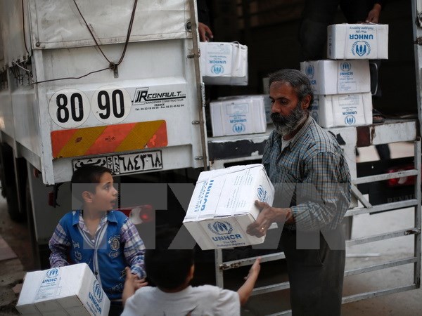 Người dân Syria nhận hàng cứu trợ tại khu vực Harasta, ngoại ô thủ đô Damascus, theo tình hình chiến sự Syria mới nhất 