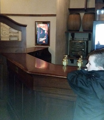 Owen, con trai của Louise đứng một mình ở quầy bar. Ảnh: Mercury Press