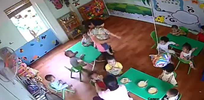 Một đoạn trong clip giáo viên (áo trắng) bạo hành trẻ mầm non (áo đỏ) vì ăn chậm đang gây xôn xao dư luận