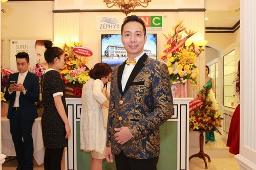 NTK Đỗ Trịnh Hoài Nam trong bộ vest cổ điển có họa tiết được dệt bằng sợi vàng với những hàng khuy và nơ vàng 9999 