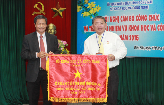 Ông Phạm Ngọc Minh, Phó cục trưởng Cục công tác phía Nam (Bộ KHCN) tặng cờ thi đua xuất sắc của Bộ cho Sở KHCN Đồng Nai