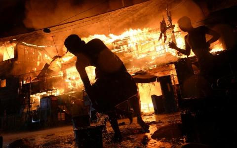 Người dân Philippines nỗ lực dập tắt đám cháy ở một khu ổ chuột tại thủ đô Manila do đốt pháo dịp Năm mới