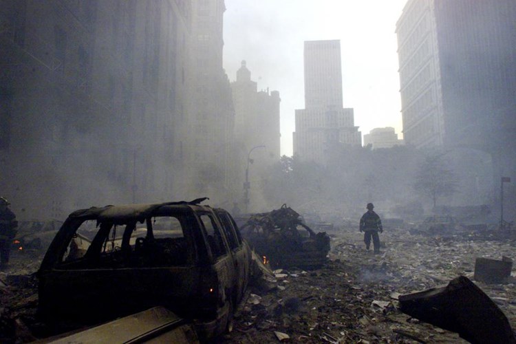 Một người lính cứu hộ đang qua đống đổ nát gần WTC bị sập ở New York hôm 11/9.