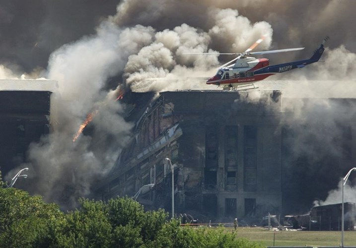 Các thành viên cứu hộ ngồi trên chiếc trực thăng đang xem thiệt hại ở một tòa nhà của Lầu Năm Góc sau khi một máy bay bị không tặc đâm vào ngày 11/9/2001. Ảnh: Reuters