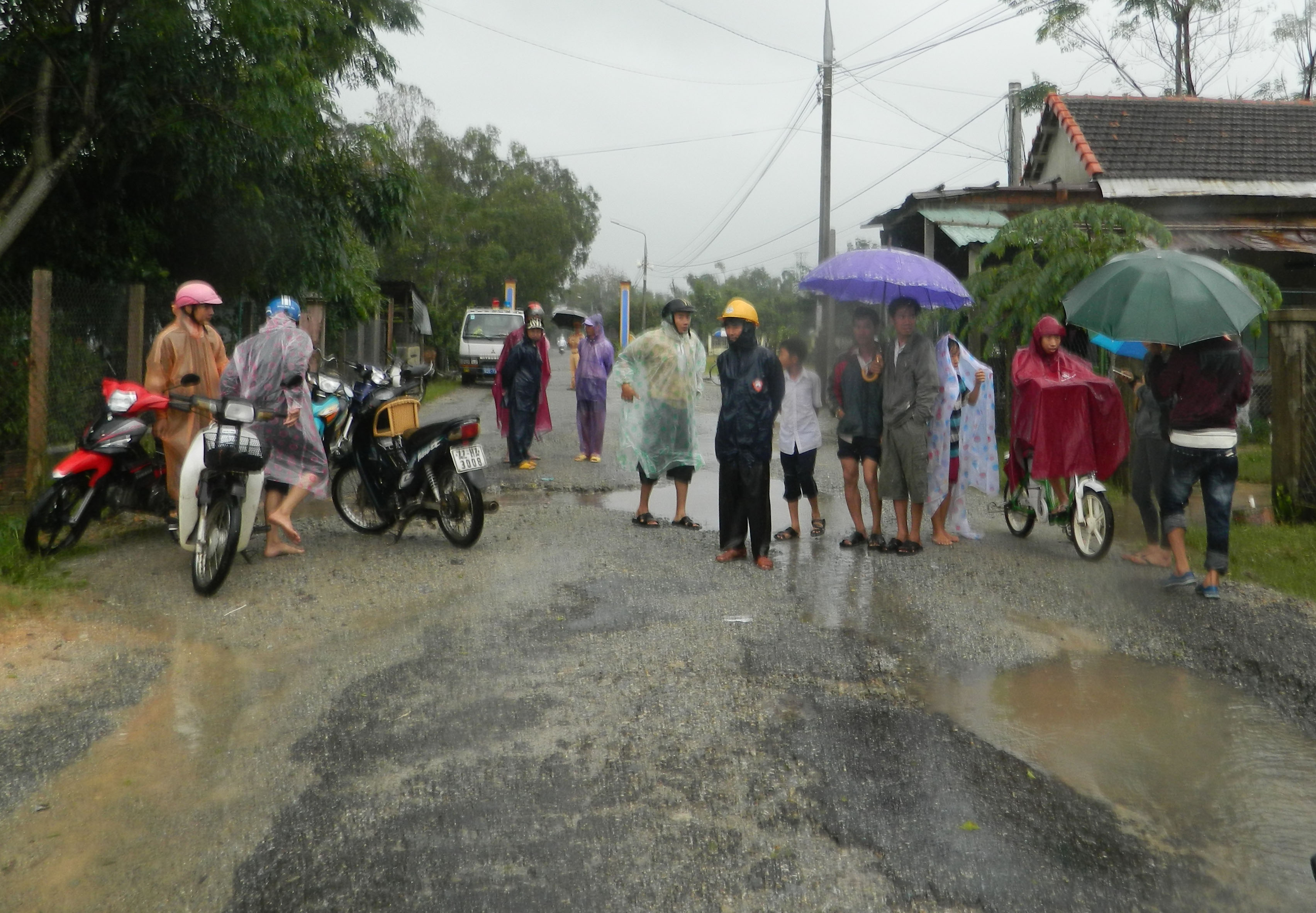 Người dân theo dõi diễn biến vụ ứng cứu mẹ con chị Vũ tại đoạn đường ngập lũ ở H.Phú Ninh. Ảnh: Thanh niên